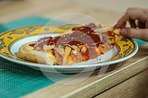 Closeup shot of a slice of pizza with ketchup