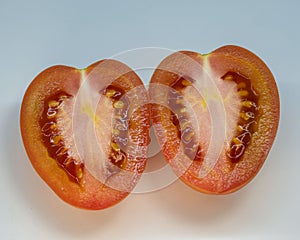 Closeup shot of the sliced roma tomatoes isolated on gray background