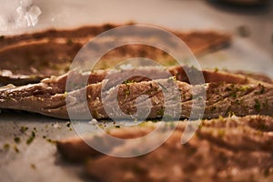 Closeup shot of sliced smelts on a table with spices and greenery on it