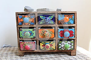 Closeup shot of a small chest with colorful ceramic drawers