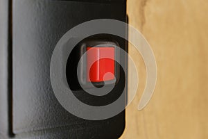 Closeup shot of a small red button switch on blurred background