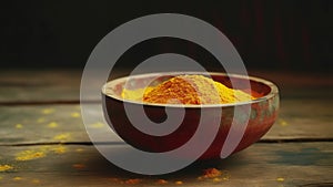 Closeup Shot Of Small Round Wooden Bowl Filled With Bright Colored Orange Turmeric Spice Composed On Shabby Wooden Table