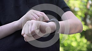 Closeup shot of smart watch with black strap on a hand of child. Sport smart wrist using. Downscale with 6k video