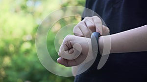 Closeup shot of smart watch with black strap on a hand of child. Sport smart wrist using. Downscale with 6k video