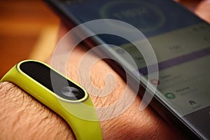 Closeup shot of a smartphone and fitness activity tracker bracelet on the wrist