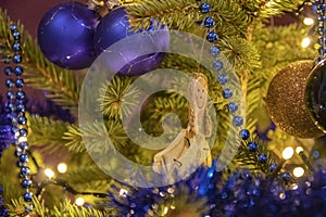 Closeup shot of a smiling female figure with balls hanging on a Christmas tress