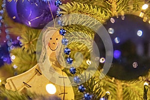 Closeup shot of a smiling female figure with balls hanging on a Christmas tress