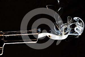 Closeup shot of a smoking gun with s black background