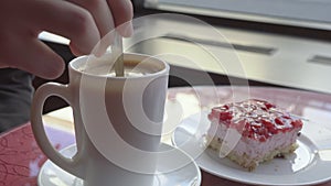 Closeup shot of someone stirring coffee in a cafe.