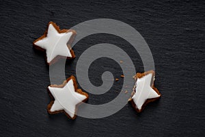 Closeup shot of star-shaped German cinnamon cookies called Zimtstern on black background