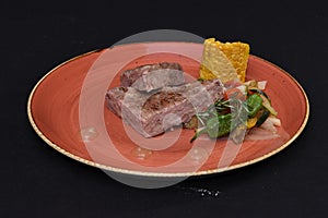 Closeup shot of steak with vegetable sidedish isolated on a black background
