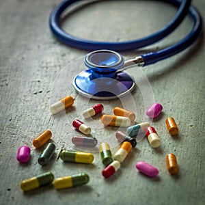 Closeup shot of stethoscope with a pile of antibiotic capsule pills