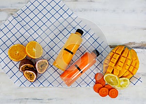 Closeup shot of summer tropical cold drink mixed juice bottle with sliced raw ripe fresh fruits mango orange lemon and passion