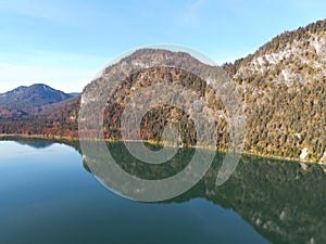 Closeup shot of the Sylvensteinsee lake reflecting hills in Germany