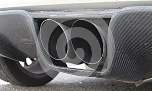 Closeup shot of a tailpipe of a car parked at a street photo