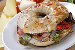 Closeup shot of tasty meat and vegetable bagel on a white plate