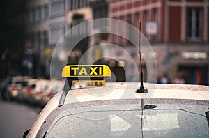 Closeup shot of a taxi sign on a car during a rainy day