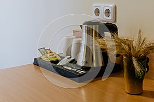 Closeup shot of a tea making set on a wooden table in the hotel room