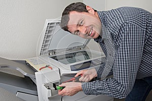 Closeup shot of technician fixing photocopier machine