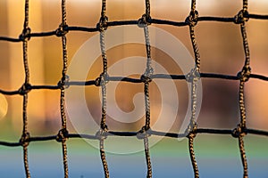 Closeup shot of a tennis court net in the late afternoon