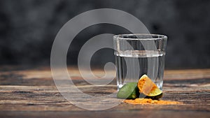 Closeup shot of a tequila shot with spicy pepper slices