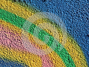 Closeup shot of a textured wall painted by multiple colors in a rainbow shape