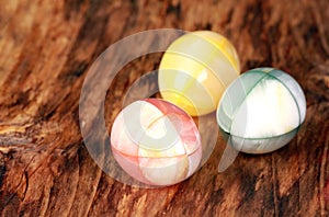 Closeup shot of three marble eggs on wooden table