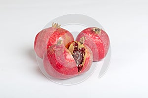 Closeup shot of three pomegranates isolated on a white background