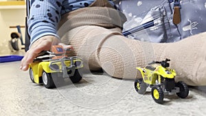 Closeup shot of a toddler playing with toy ATVs.