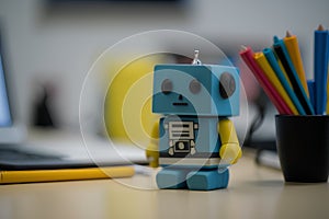 A closeup shot of a toy robot sitting on a desk at home