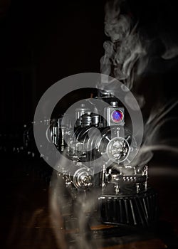 Closeup shot of a toy train with a locomotive steam engine against a dark background