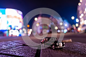 Closeup shot of a traditional black cab driving through the most famous landmarks in London