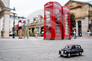 Closeup shot of a traditional black cab driving through the most famous landmarks in London