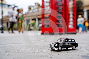 Closeup shot of a traditional black cab driving through the most famous landmarks in London