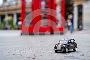 Closeup shot of a traditional black cab driving through the most famous landmarks in London