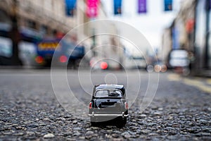 Closeup shot of a traditional black cab driving through the most famous landmarks in London