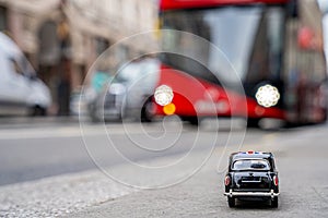 Closeup shot of a traditional black cab driving through the most famous landmarks in London