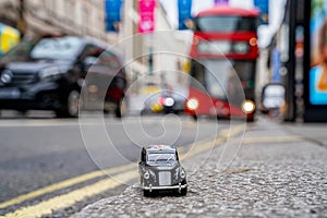 Closeup shot of a traditional black cab driving through the most famous landmarks in London