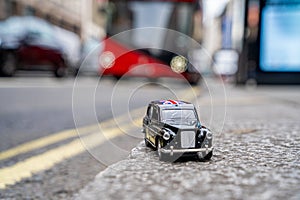 Closeup shot of a traditional black cab driving through the most famous landmarks in London