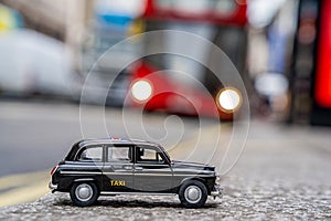 Closeup shot of a traditional black cab driving through the most famous landmarks in London