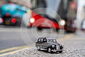 Closeup shot of a traditional black cab driving through the most famous landmarks in London