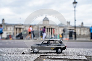 Closeup shot of a traditional black cab driving through the most famous landmarks in London