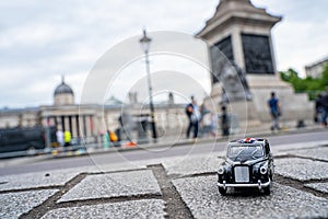 Closeup shot of a traditional black cab driving through the most famous landmarks in London