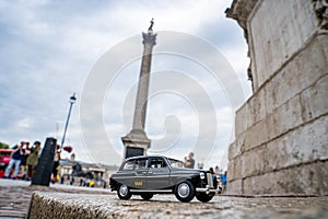 Closeup shot of a traditional black cab driving through the most famous landmarks in London