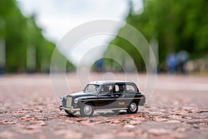 Closeup shot of a traditional black cab driving through the most famous landmarks in London