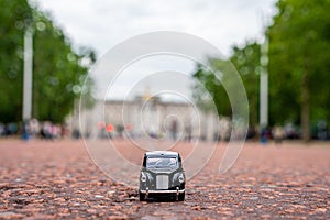 Closeup shot of a traditional black cab driving through the most famous landmarks in London