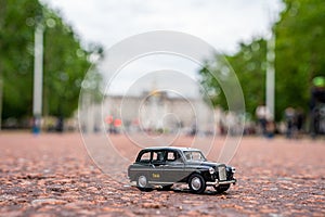 Closeup shot of a traditional black cab driving through the most famous landmarks in London