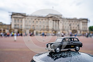 Closeup shot of a traditional black cab driving through the most famous landmarks in London