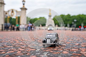 Closeup shot of a traditional black cab driving through the most famous landmarks in London