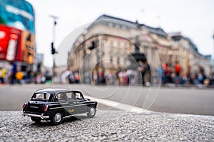 Closeup shot of a traditional black cab driving through the most famous landmarks in London